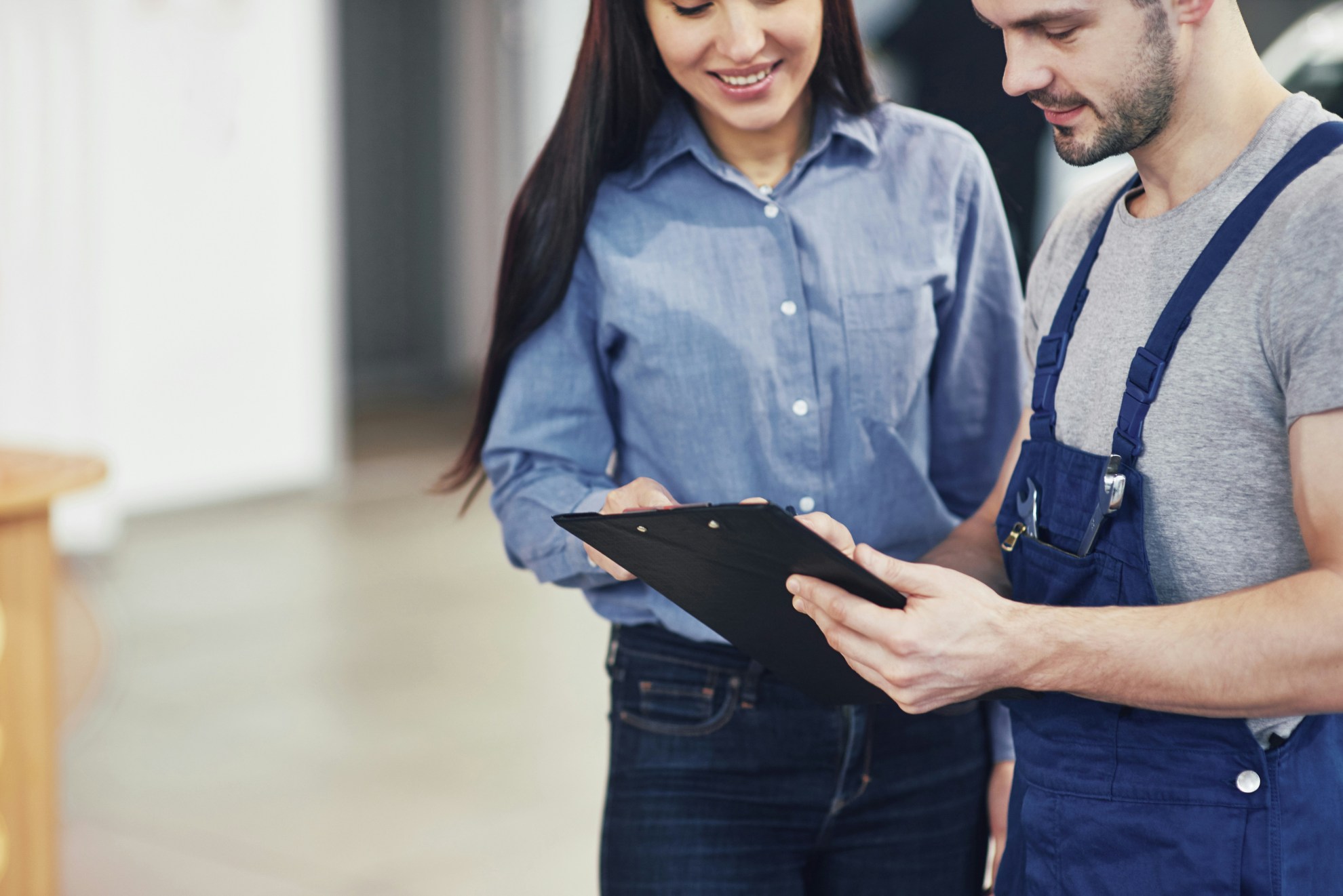 A repair man talking with a women, picture is for a garage door opener service blog
